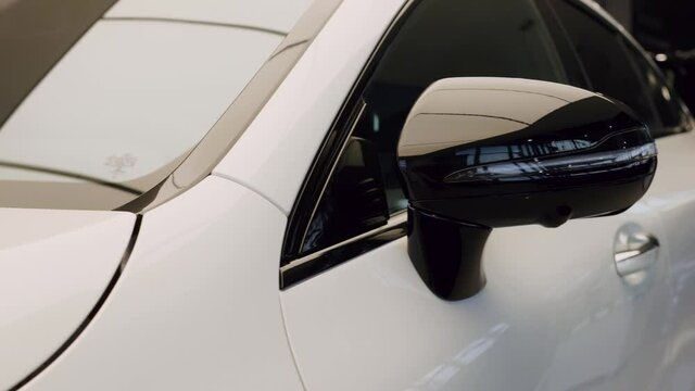 Close-up of white car side view mirror.