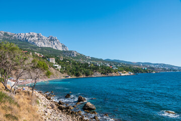Sea view with rocky beaches and cliffs. Tourism in the Crimea. Summer photo of a sea landscape.