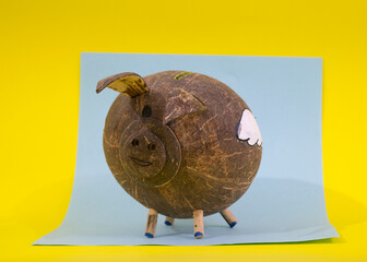 coconut piggybank with clouds in blue and yellow background