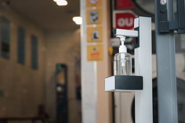 A bottle of alcohol is placed in front of the door for people to use to wash their hands before entering the building.