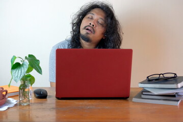 tired asian man sleep in front laptop, funny exhausted man while working at home
