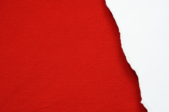 Surface Of Torn White Paper Placed On Blank Red Fabric .