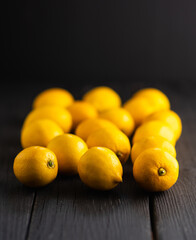 Ripe bright lemons on the dark rustic background. Selective focus. Shallow depth of field.