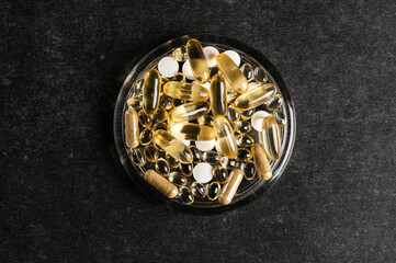 set of vitamin D, omega 3-6-9, zinc, yellow capsules on a dark background