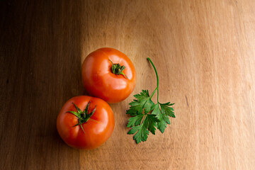 Red tomatoes and parsley on the wood table