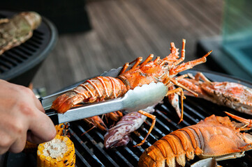 Lobster, rock lobster and mix seafood barbecue cokking on grill stove