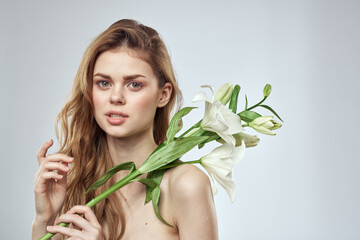 Naklejka premium girl with flowers cropped view portrait close-up spring bare shoulders clear skin Make Up
