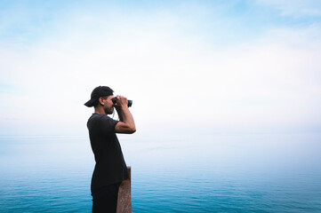 Obraz premium Man with binoculars looking forward through the fog, Koh Phangan, Thailand