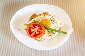 Roasted egg sandwich with tomato, pepper and green onions on toast