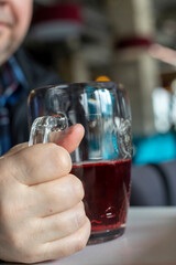 drinking red cider in a glass goblet, vertical.