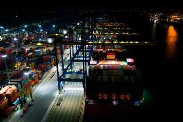 Rear view of Containers cargo ship at night. Business logistic transportation sea freight, Cargo ship, Cargo container in deep sea port at industrial estate for import export around in the world