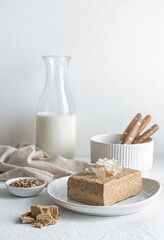 Halva with seeds and milk on a light background.
