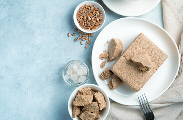 Halva, sugar, seeds on a blue background with space to copy.