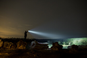 Man With Flashlight in Outdoor at Night