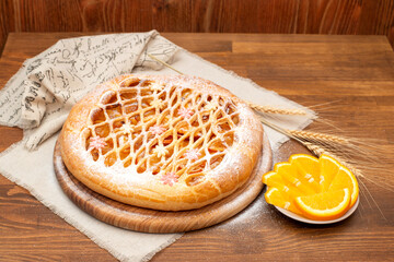 candied fruit pie on a linen towel decorated with candied fruit on a wooden table. Close-up. Homemade baking.