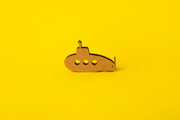 toy wooden submarine over yellow background