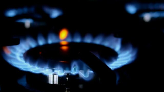 Process of burning and appearing blue flame of gas methane or propane on kitchen gas stove. Kitchen burner switching. Natural gas inflammation. Selective focus.