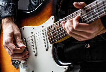 Man playing guitar. Close up hand playing guitar. Musician playing guitar, live music. Musical instrument. Electric guitar. Repetition of rock music band. Music festival