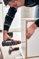 Handyman worker assembling furniture and fixing it.