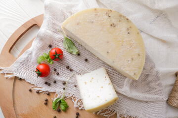 Medium hard cheese head parmesan on wooden board, with cheese parmesan with tomatoes on the table
