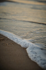 wave with foam at sunset