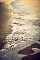 wave with foam at sunset