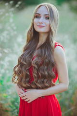 Young beautiful girl in a red dress in nature