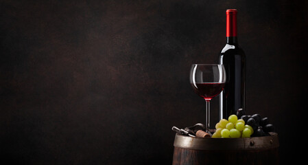 Wine bottle, glass and old wooden barrel