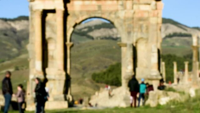 Blurred group of people walking between the ancient Roman ruins of the Djemila in Setif, Algeria 