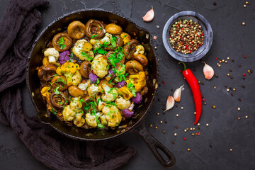 Roasted mushrooms and cauliflower, with onion and herbs in pan