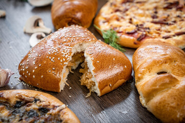 Puffs with spinach, eggs, green onions and cheese sprinkled with sesame seeds on wooden background, selective focus.