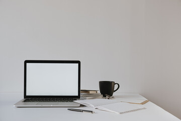 Minimalist home office desk workspace. Laptop with blank copy space mockup on table with coffee...