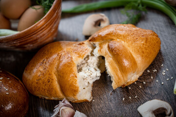 Puffs with spinach, eggs, green onions and cheese sprinkled with sesame seeds on wooden background, selective focus.