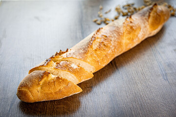 Fresh baked bread and sliced bread on rustic wooden table