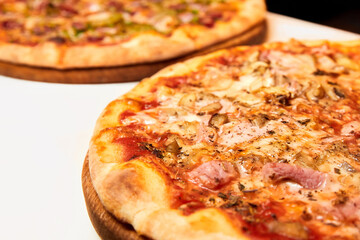 Pizza with cheese, bacon and tomatoes on wooden board. Close-up, selective focus