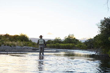 Fototapeta premium Fisherman walking in a river in Patagonia