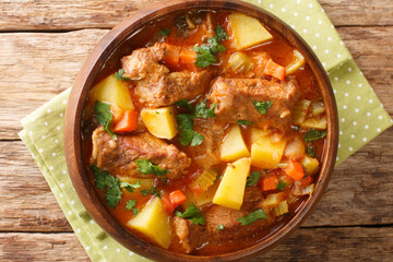 Traditional Italian beef stew with wine and vegetables close-up in a bowl on the table. horizontal top view above