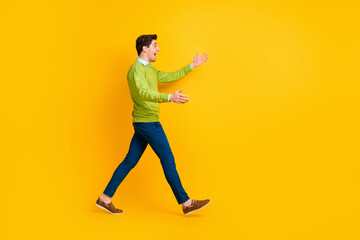 Fototapeta na wymiar Full length body size profile side view of nice cheerful guy walking meeting hugging invisible friend isolated over bright yellow color background