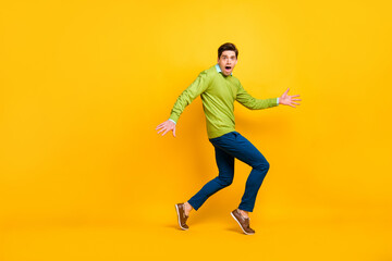 Fototapeta na wymiar Full length body size profile side view of nice funky confused guy sneaking escaping tiptoe isolated on vivid yellow color background