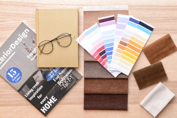 Color palettes, notebook and fabric samples on wooden background