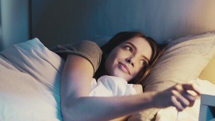 Good night. Sweet dreams. Bedtime rest recreation. Happy relaxed satisfied woman lying down in cozy comfortable bed turning off light falling asleep smiling in dark bedroom with blue moonlight. - Powered by Adobe