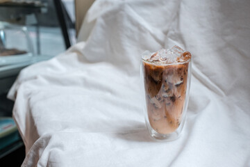 glass of coffee with milk on a white canvas