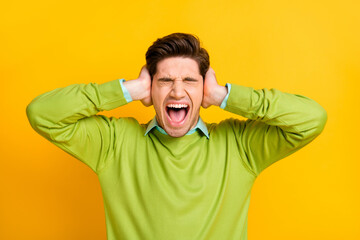 Fototapeta na wymiar Close-up portrait of outraged brown-haired guy closing ears yelling loudly rage isolated on bright yellow color background