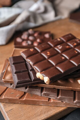 Different chocolate bars on wooden background, closeup