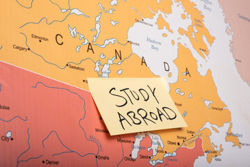  study abroad written on a sticky note attached with the canada country on world map.