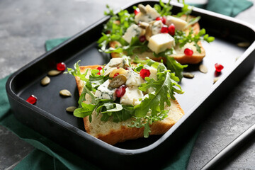 Plate with arugula toasts on table