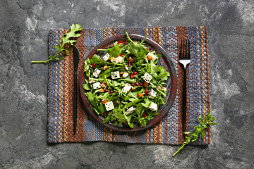 Plate with arugula salad on grunge background