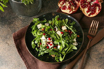 Plate with arugula salad on grunge background
