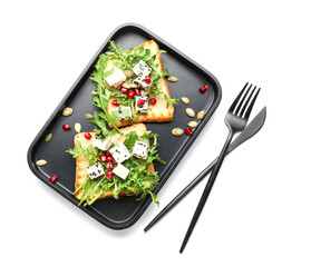 Plate with arugula toasts on white background