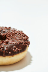 Mmm, so yummy. Close up shot of a freshly baked delicious chocolate donut with sprinkles on white background